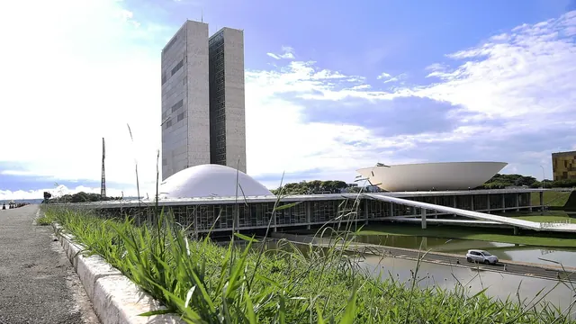 Congresso Nacional em Brasília sob céu azul, com o espelho d'água