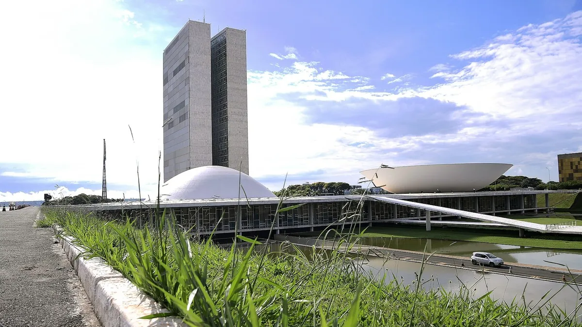 Congresso Nacional em Brasília sob céu azul, com o espelho d'água